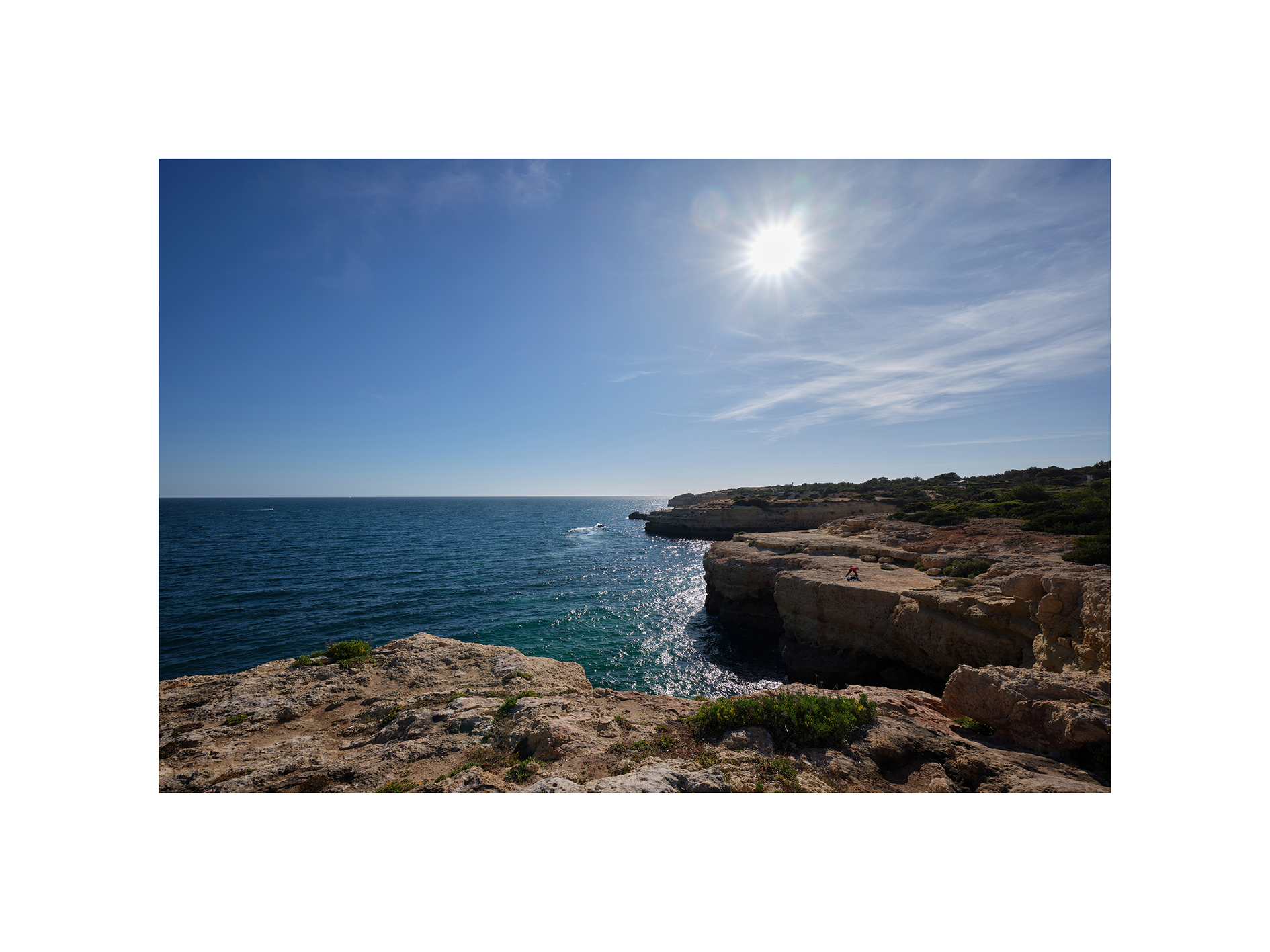 Angler – Algarve, Portugal 2024 Ein Angler auf einer Felsklippe an der Algarve, umgeben vom Atlantik und einer weiten Küstenlandschaft im Gegenlicht.